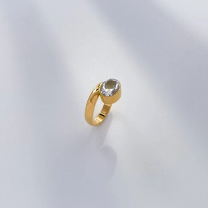 Detailed view of an 18K gold plated ring with an oval zircon stone in a bezel setting
