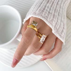 Detail of 18K gold-plated rings featuring large rectangular cubic zirconia on model hand