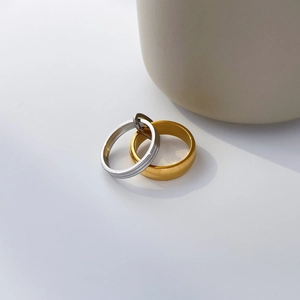 Detail of minimalist 18K gold and silver rings with smooth and textured surface finishes