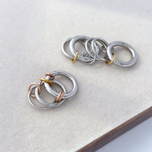 Close-up of interlocking multi-tone titanium rings with polished silver and gold finish