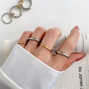 Detail of minimalist tri-color interlocking chain rings on model with silk sleeve