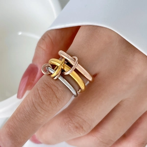 Detailed view of interconnected three-color titanium steel rings in gold, silver, and rose gold