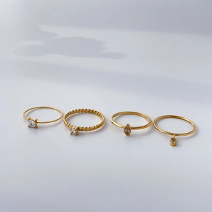 Set of four gold-plated titanium rings with zircon eye charms and twisted rope bands