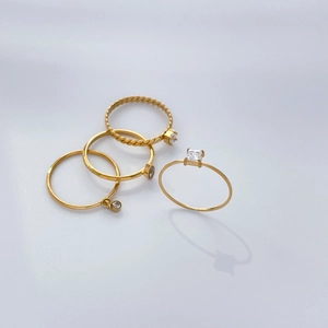 Four-piece gold titanium steel ring set with twisted texture and zircon stones