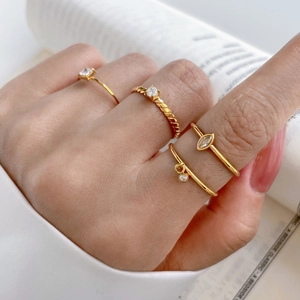 Gold titanium steel stacked ring set with cubic zirconia eye charms and twisted bands