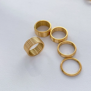 Detail of 18K gold-plated titanium rings set featuring ribbed and stacked wave patterns