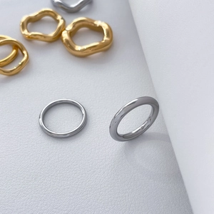 Macro view of minimalist gold wave and silver smooth stackable titanium steel rings