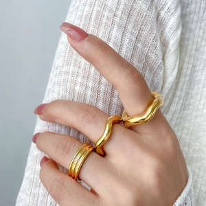 Three-piece stackable 18K gold-plated wave rings set with polished smooth finish