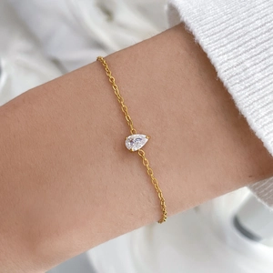 Gros plan d'un bracelet minimaliste plaqué or 18 carats orné d'un zircon en forme de poire