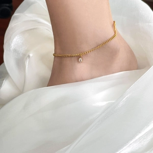 Détail de la chevillère plaquée or 18K avec zircon ovale sur soie blanche