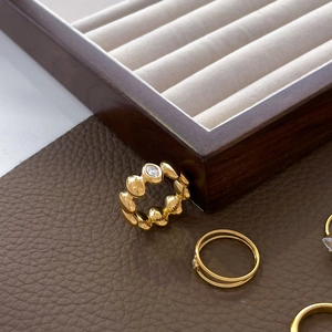 Detail of 18K gold plated titanium ring with teardrop zircon on premium leather background