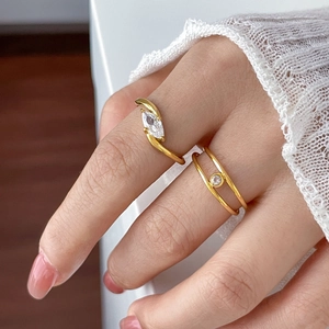 Detailed view of marquise-cut zircon ring and double-layered gold band on finger