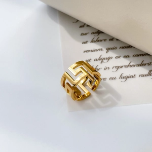 Vue détaillée d'une bague large dorée avec un motif géométrique abstrait et ajouré