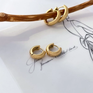 Détail des boucles d'oreilles créoles plaquées or 18 carats avec motif pneu texturé
