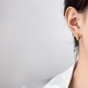 Créoles dorées avec texture de pneu en acier inoxydable plaqué or 18 carats sur mannequin