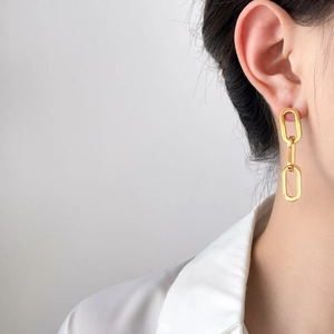 Minimalist gold-plated stainless steel triple link chain earrings worn by a model