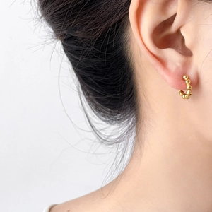 Polished 18K gold plated beaded hoop earring shown on ear for minimalist style look