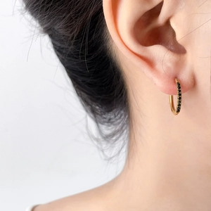 U-shaped 18K gold plated hoop earrings with black zircon stones shown worn on ear
