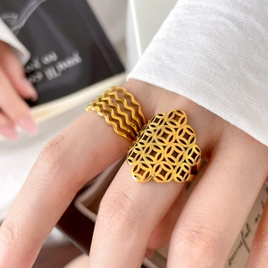 Detailed view of gold multi-layer wave ring and hollow coin pattern titanium steel band