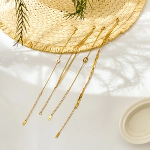 Daisy charm and multilayer gold chain link bracelet set for women on white surface