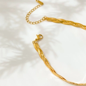 Macro detail of gold daisy multilayer chain bracelet with lobster clasp and 18K tag