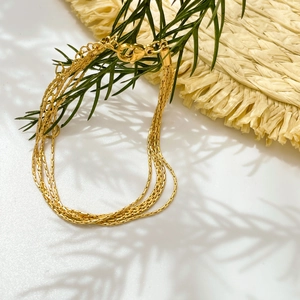 Detail of a multi-layer gold titanium steel daisy chain bracelet with adjustable clasp