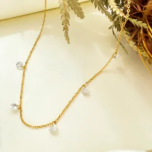 Détail du collier de clavicule doré avec breloques en zircon sur surface neutre