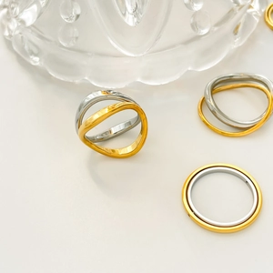 Macro shot of 18K gold and silver plated titanium steel wave rings on a white surface
