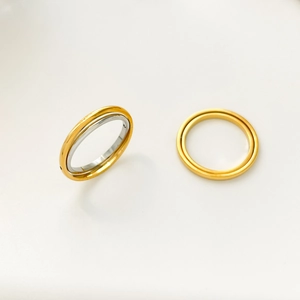 Detail view showing dual-tone nesting design and minimalist gold ring on white background
