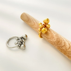 Detailed view of bicolor clustered metal beads ring in gold and silver finish