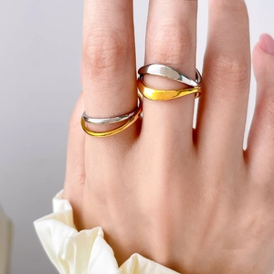 Detail of two-tone curved wave ring in 18K gold and silver plated titanium steel