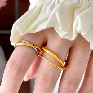 Close-up of dual-layer wavy 18K gold plated titanium rings with a polished two-tone finish
