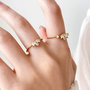 Détail de deux bagues en titane plaqué or 18K avec fleurs en zircon taille marquise