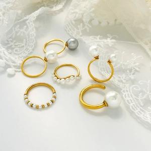 Set of 6 gold titanium steel rings with elegant freshwater pearls and lace background
