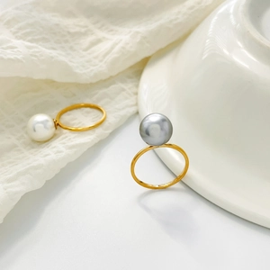 Detail of elegant gold titanium rings with large white and silver freshwater pearls