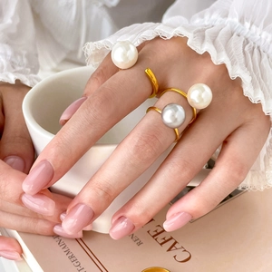 Elegant gold titanium steel open ring with glossy freshwater pearls worn by a model