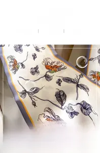Detail of elegant floral long silk scarf featuring smooth fabric and premium stitching