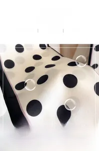 Detailed view of polka dot silk scarf featuring smooth fabric texture and pink stitched edges
