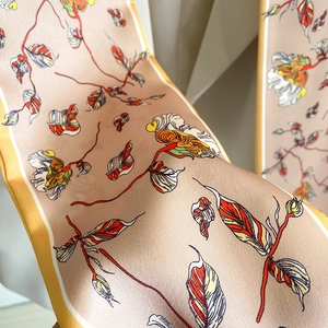 Detailed view of floral silk scarf with hand-painted leaves and vibrant yellow edges
