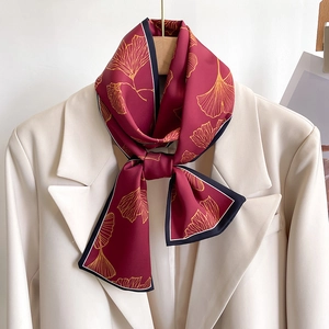 Elegant skinny silk scarf with golden ginkgo leaves on burgundy fabric for women