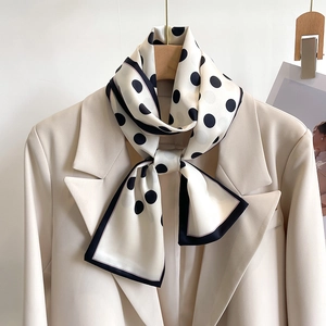 Polka dot silk scarf necktie for women tied elegantly on a beige blazer collar