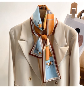 Detail of color-blocked horse pattern silk scarf styled as an elegant necktie on a beige blazer