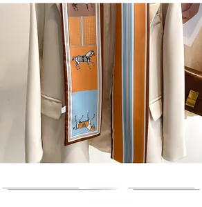 Detail of printed skinny silk scarf with horse motif styled on a beige suit and brown bag