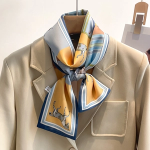 Elegant skinny silk scarf with classic horse print in blue and yellow on beige blazer