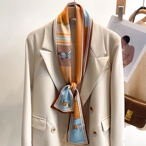 Close-up of a vintage horse print silk scarf styled on a beige blazer collar