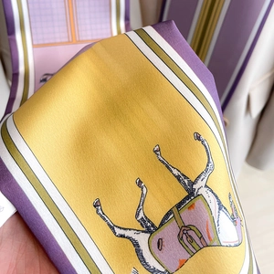 Detail of silk scarf with artistic horse pattern and vibrant satin finish texture