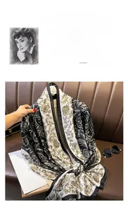 Detailed view of silk scarf with paisley pattern on brown leather sofa with sunglasses