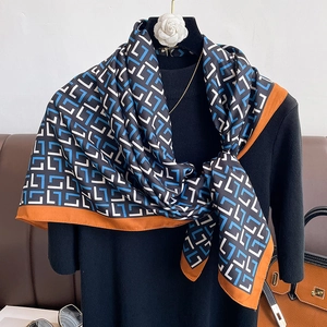 Elegant geometric print silk scarf with orange border and blue patterned letter design
