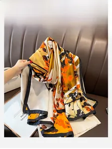 Detailed texture of an orange leaf pattern silk scarf with elegant black borders