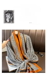 Close-up of silk scarf with black and white geometric pattern and orange rolled edges